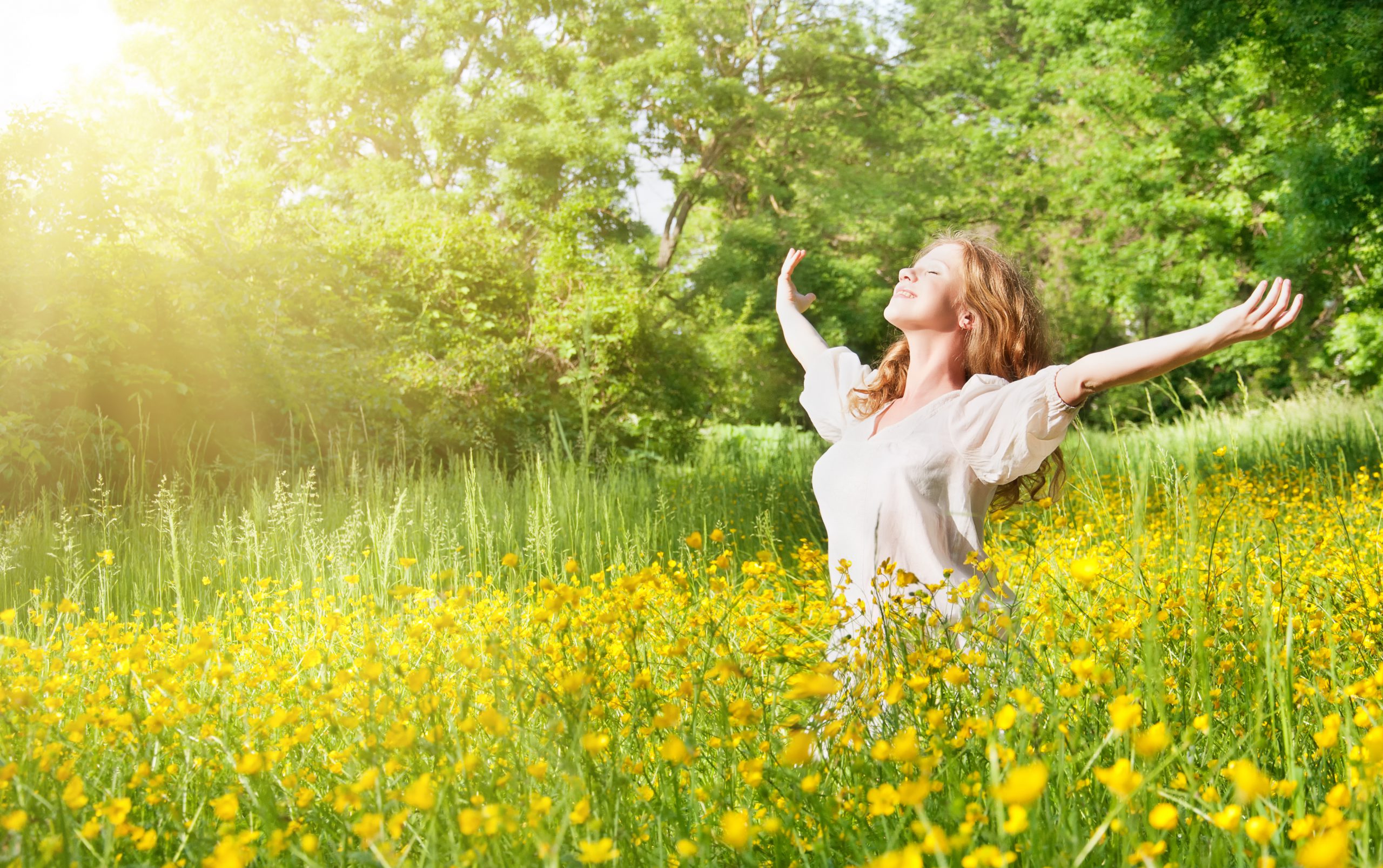 Eine Frau steht in einer Blumenwiese